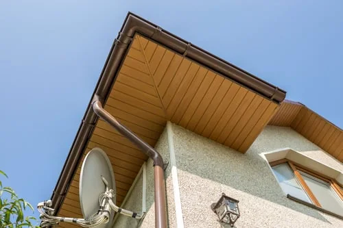 Seamless gutter and downspout installed along a roofline